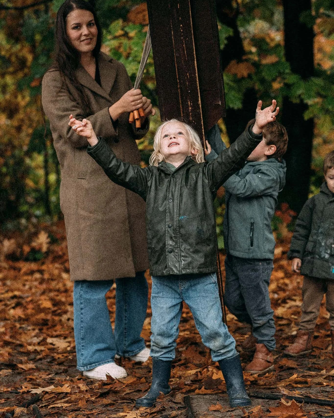 Begeleider met kinderen bij het stokvangen in het bos