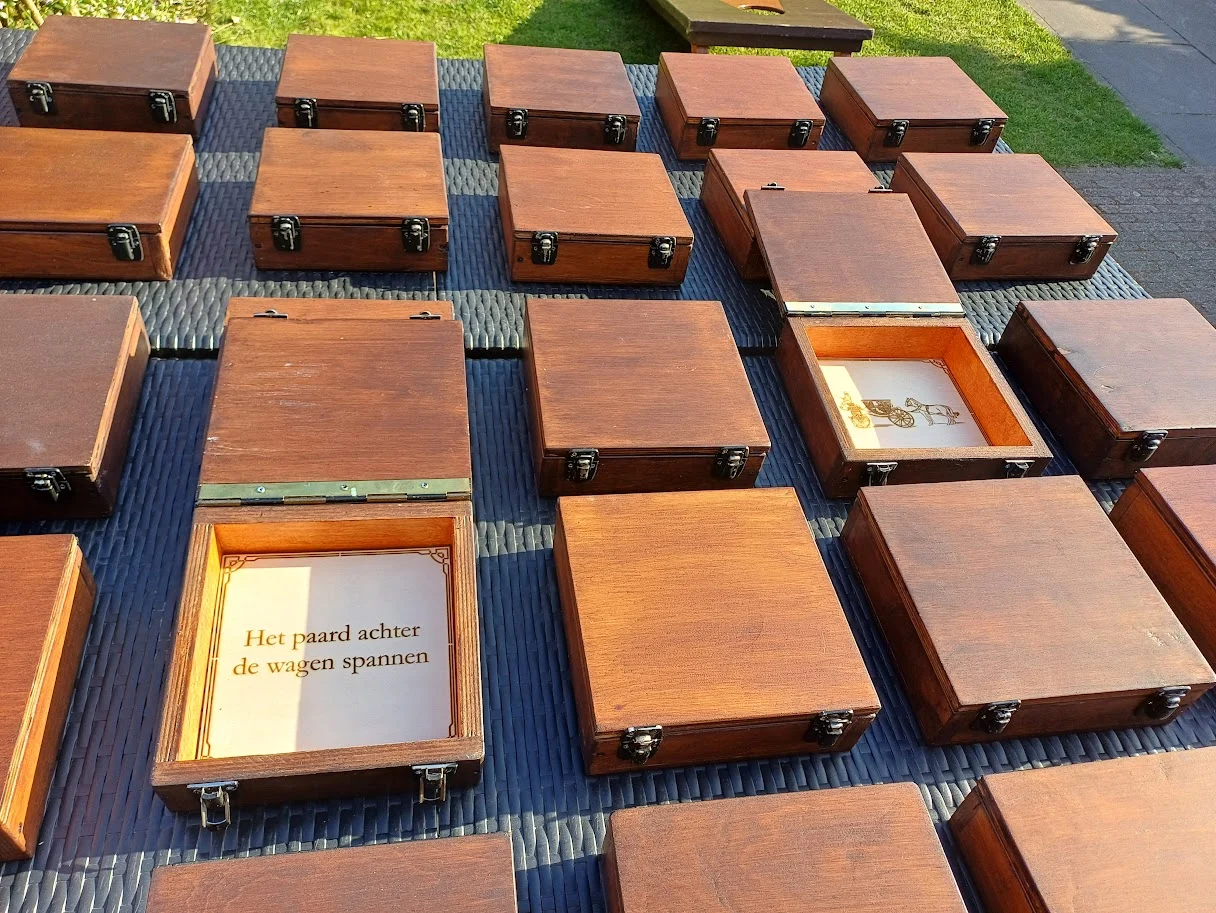 Kistjes van memospel XL op tafel, één geopend met een spreekwoord