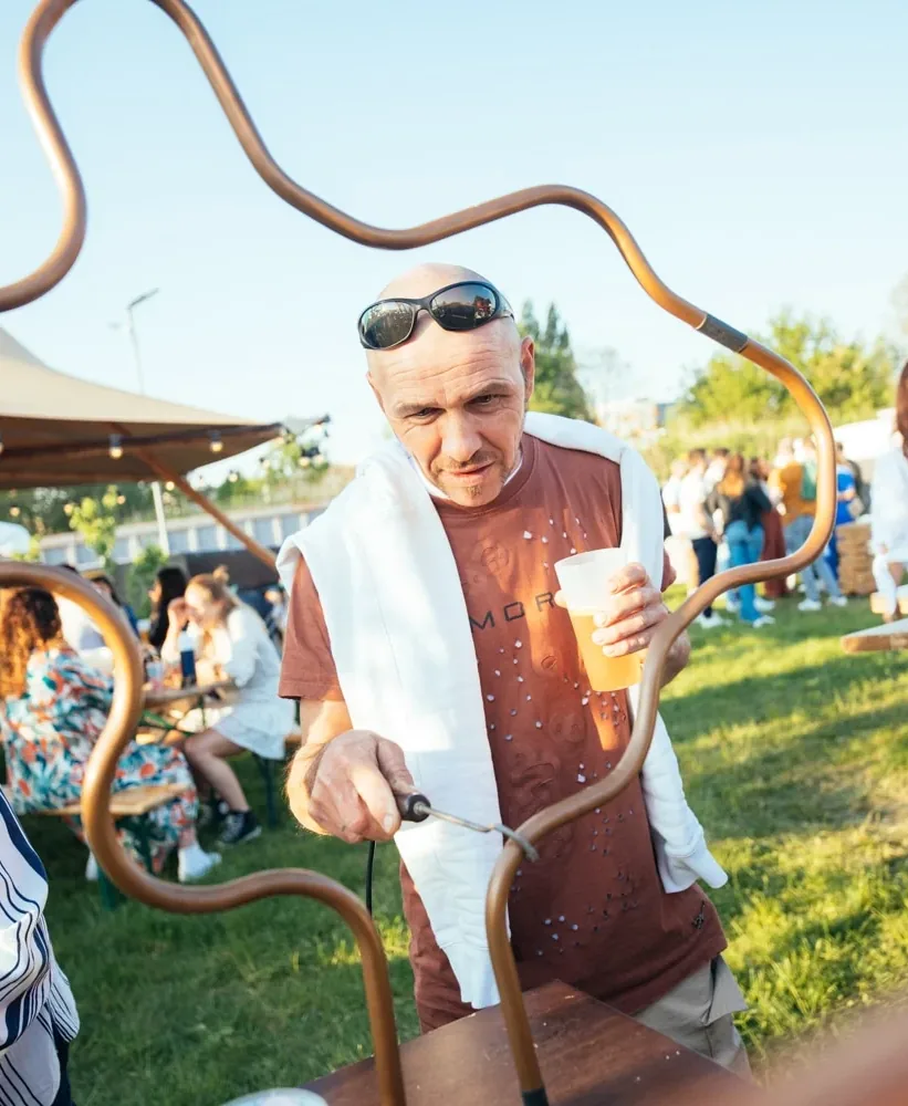 Man met een drankje in de hand bij de spiraalboom