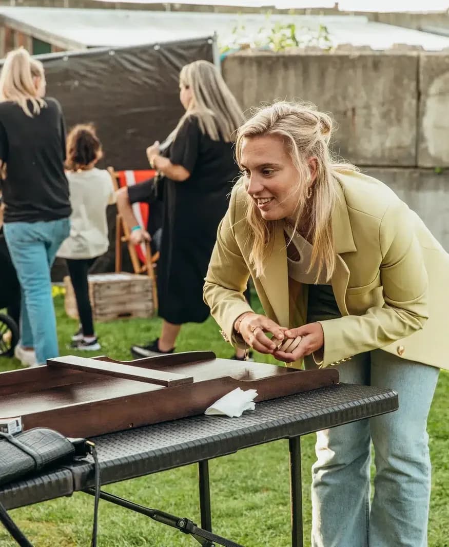 Vrouw lacht bij een houten tafelspel op het gras