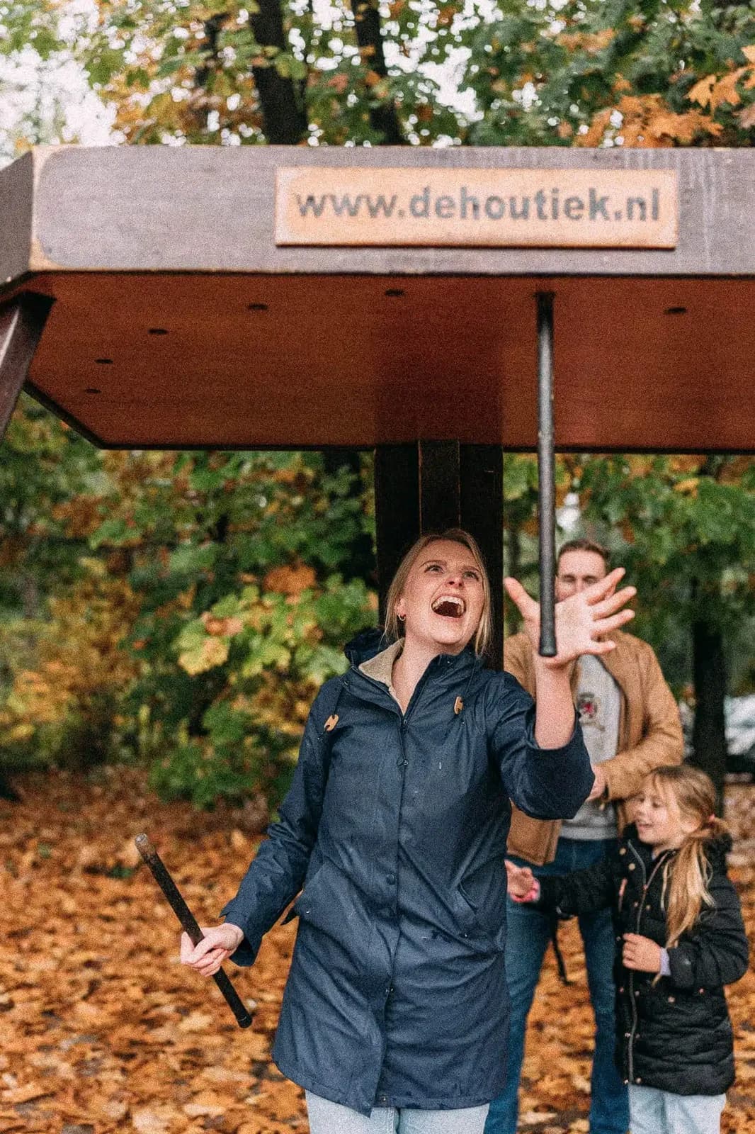Vrouw lacht terwijl ze bij het stokvangen naar de vallende stokken grijpt