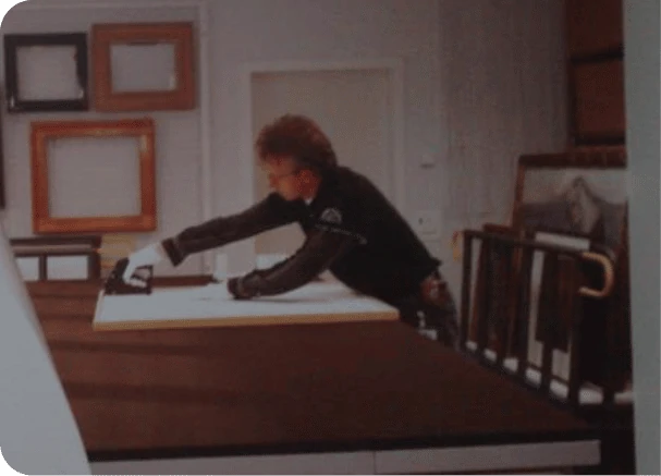 Jaap gebogen over een werktekening op de werkbank