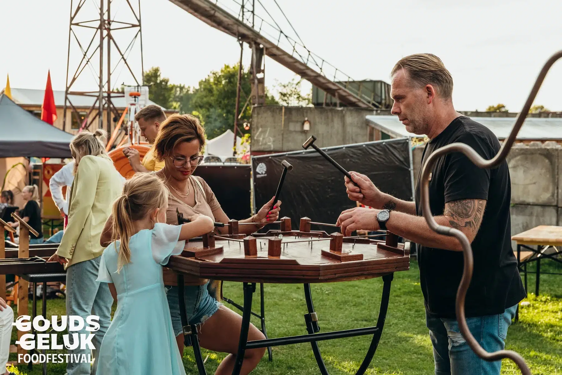 Collega's spelen hamerspel op een festivalterrein