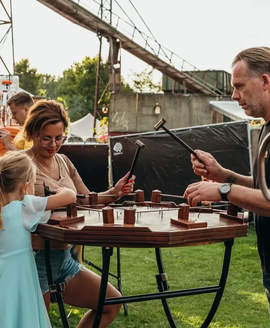 Collega's spelen hamerspel op een festivalterrein