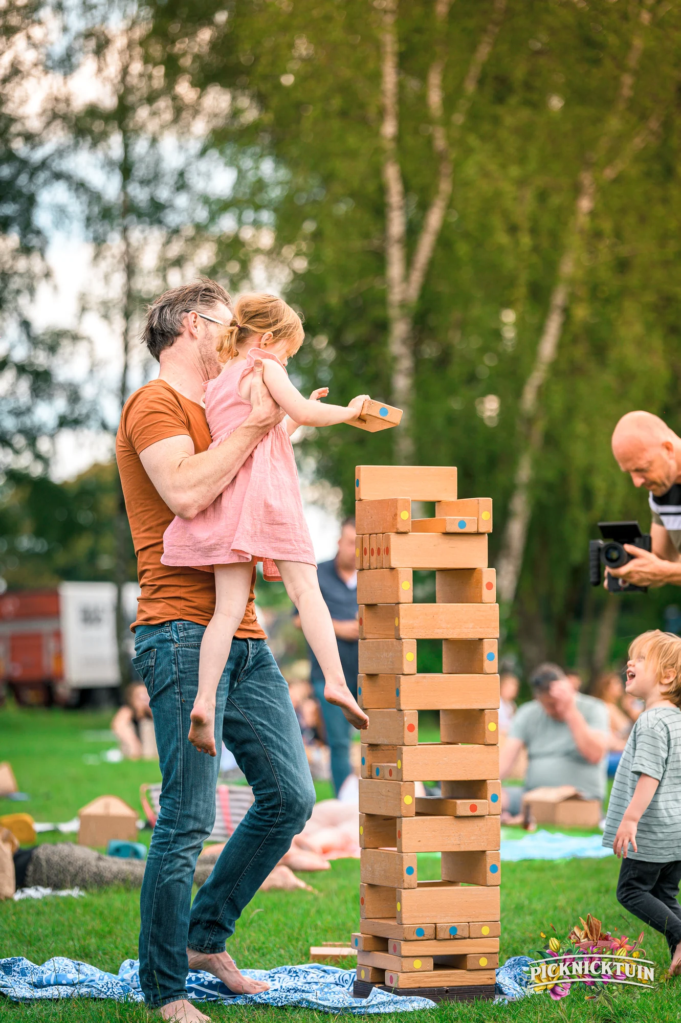 Vader tilt zijn dochter op bij de grote vallende toren in het park