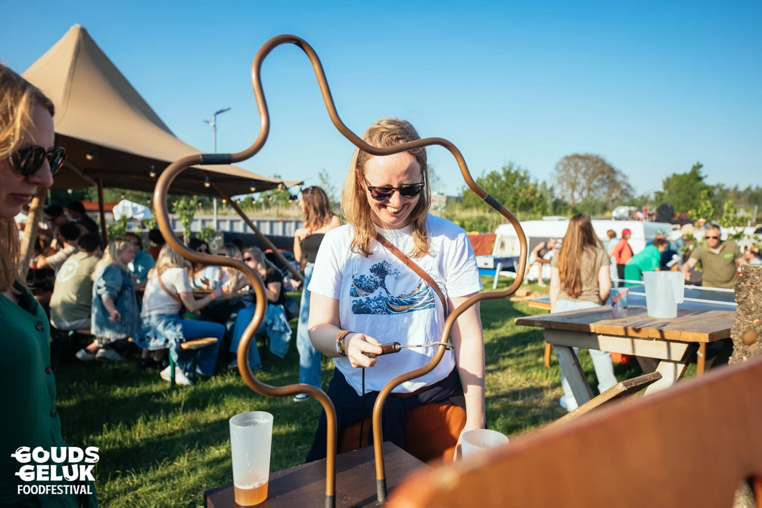 Vrouw speelt spiraalboom in de zon op een festival